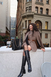 a lady in a coffee brown cloak and vest two-piece set and a pair of leather boots